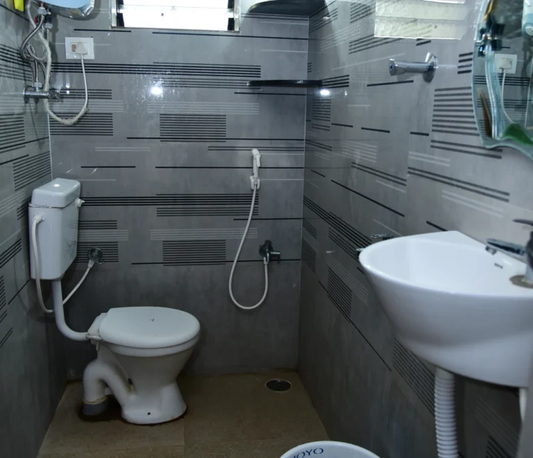 The image displays a bathroom from a homestay accommodation located in Mantralayam, India.