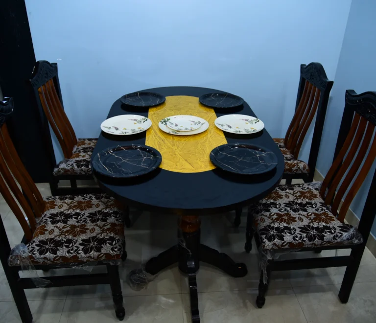 This is a 4-seater wooden dining table set with black chairs featuring patterned seat cushions.